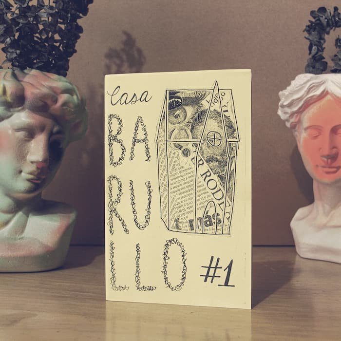 Fanzine Casa Barullo número 1 apoyado sobre una mesa, con dos bustos decorativos a los lados